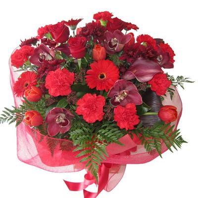 Red flower bouquet of roses red, red orchids, red gerberas, red tulips in large red bouquet with red wrapping and ribbon.