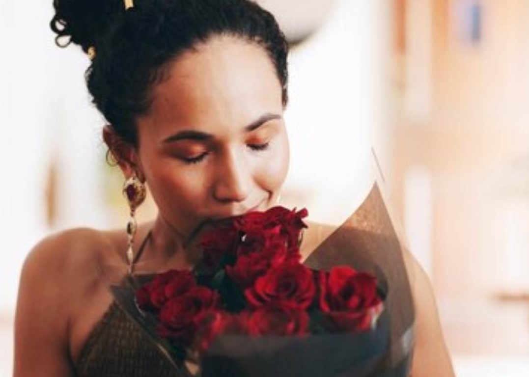 Woman sniffing red rose bouquet