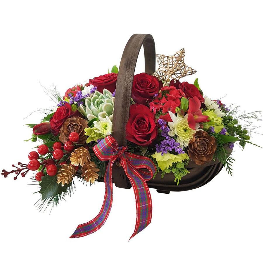 Side view of Christmas floral arrangement in wooden trug basket