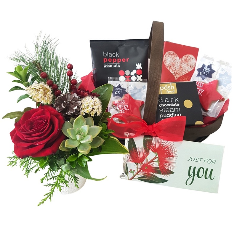 Christmas gift basket with festive treats and petite floral arrangement
