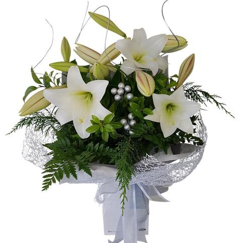White Christmas Lilies Auckland delivery. Bouquet of longiflorum xmas lilies in silver wrapping with twisted willow twigs.
