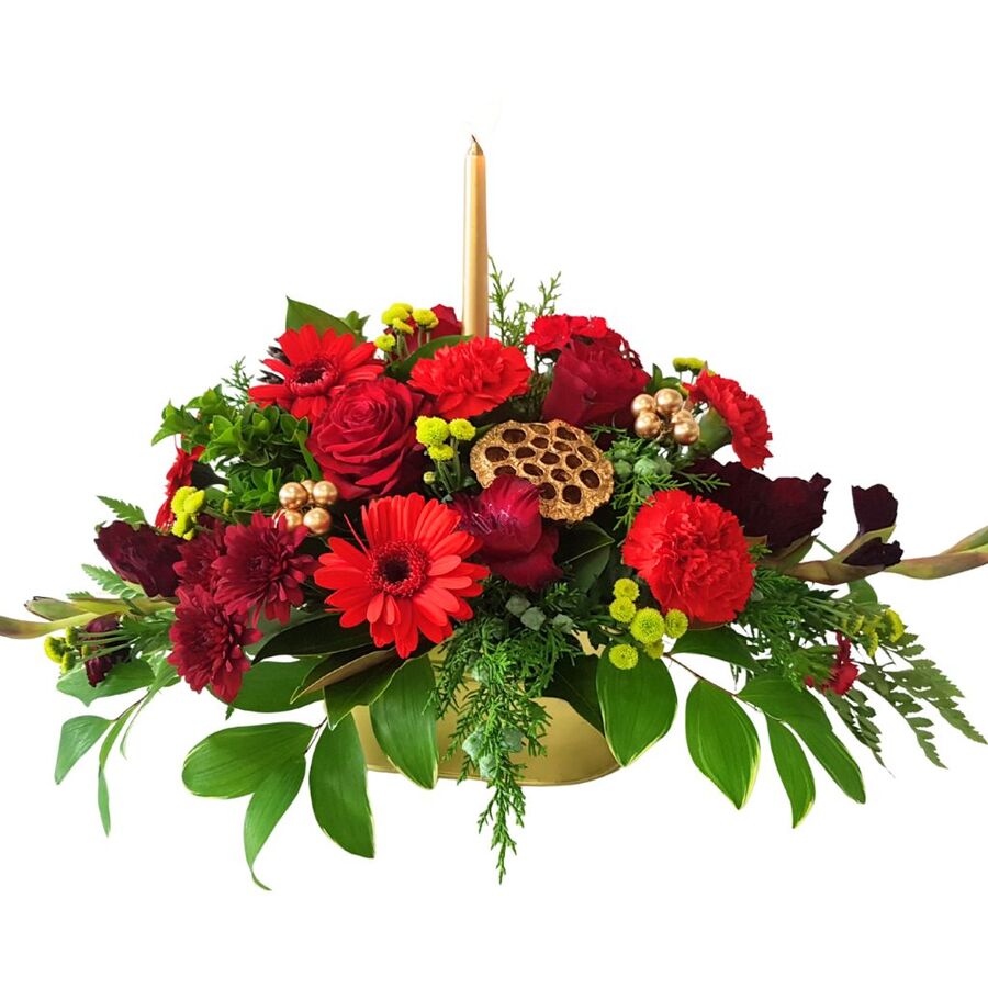 Christmas floral table centrepiece with candle in red and green festive colours
