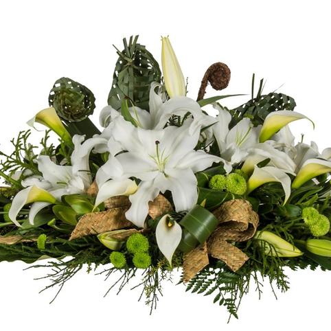 white lily floral casket spray with flax flowers