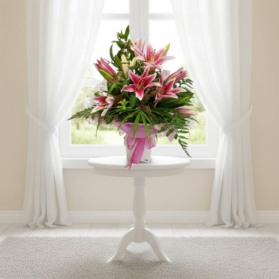 Pink lily bouquet in vox box sitting on table in styled scene