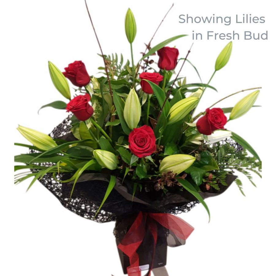 red roses & white lilies in tight fresh bud bouquet.