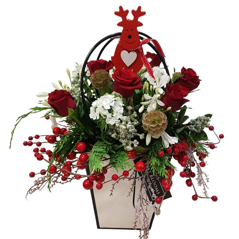 Christmas flower arrangement with reindeer and berries