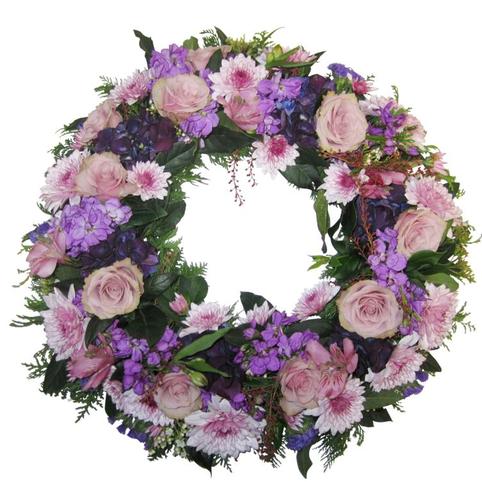 purple mauve funeral wreath in seasonal flowers. Purple flowers, lavender, mauve. Roses, chrysanthemums, stock, freesias.