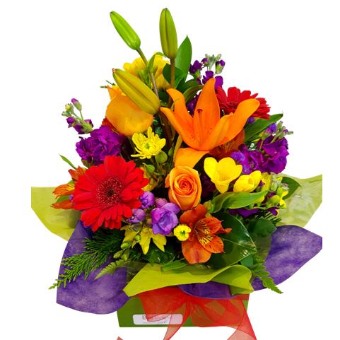 Bright colourful Flower Arrangement in box. Orange Lilies, gerberas, freesias, stock, alstroemarias. Auckland Florist.