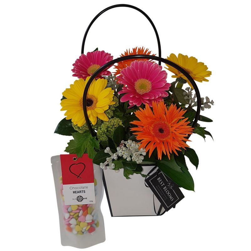 bright gerberas arranged in handbag with floral fields hand cream 