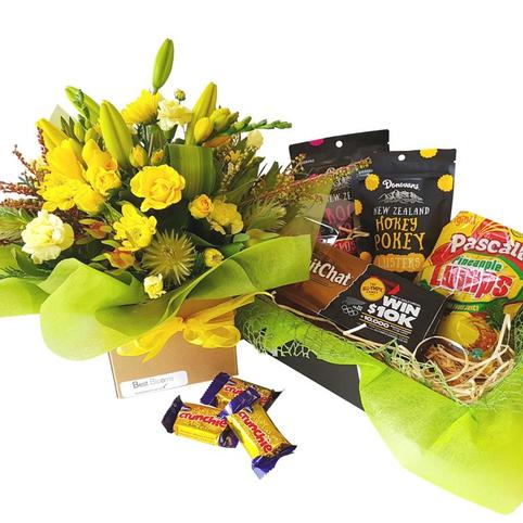 Bright Flowers and Chocolate Treats close up showing chocolates style included in gift basket. Crunchie bars, maltesers, cadbury dairy milk, picnic.