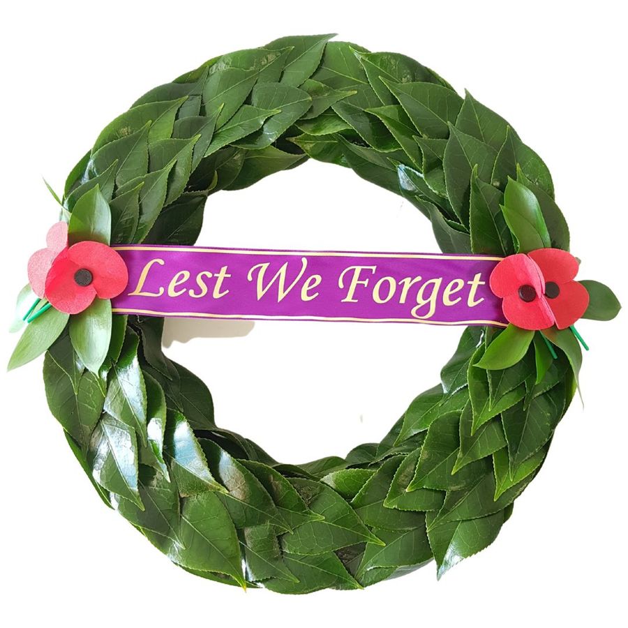 Anzac Wreath of traditional green leafing pattern of fresh leaves. Lest we Forget ribbon. RSA Red Poppies.