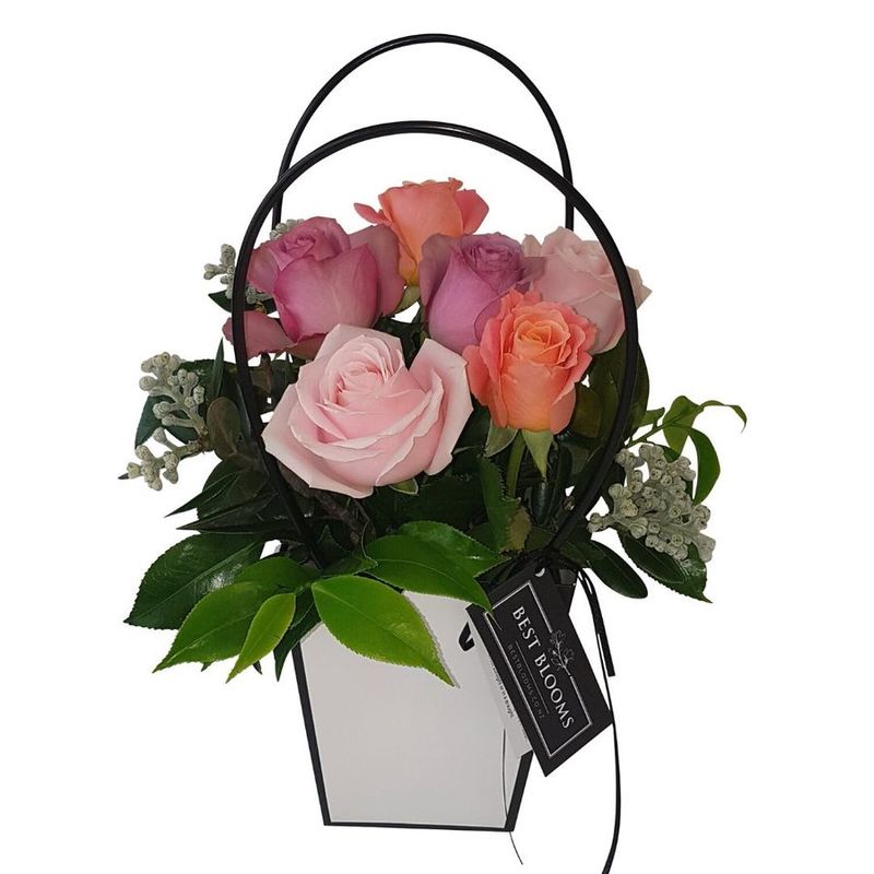 pastel roses arranged in handbag in peach, pink and mauve roses