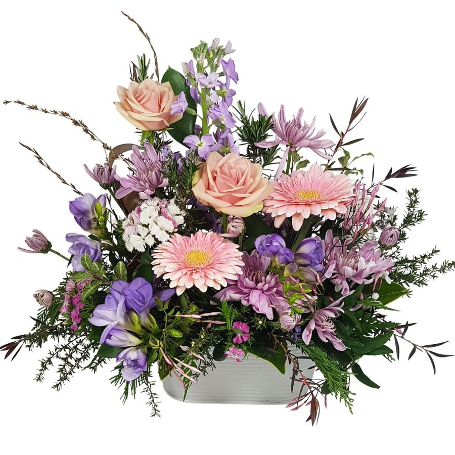 arrangement of flowers in tin trough in soft pinks and pastels.