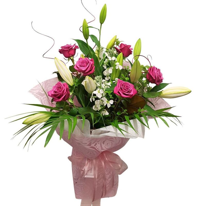 pink roses white lilies in pink wrapping bouquet